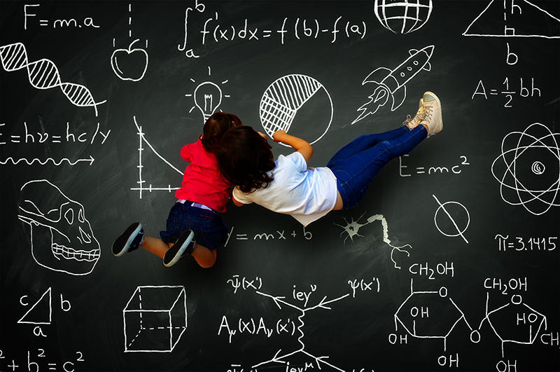 boy girl writing on blackboard with science subjects